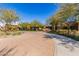 Attractive clubhouse entrance with a circular driveway and lush landscaping under a clear sky at 5624 S Winchester --, Mesa, AZ 85212