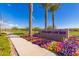 Landscaped community entrance sign featuring colorful flowers and towering palm trees on a bright day at 5624 S Winchester --, Mesa, AZ 85212