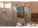 Modern bathroom featuring tiled shower with glass door, decorative artwork and neutral-toned walls at 5705 S Pinnacle Ln, Gold Canyon, AZ 85118