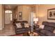 Cozy living room with brown sofas, neutral walls, decorative lighting, and an arched entryway under a neutral light at 5705 S Pinnacle Ln, Gold Canyon, AZ 85118