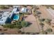 Expansive aerial view showcasing the property's equestrian facilities, including arenas, stables, and a serene pool area at 5914 E Dale Ln, Cave Creek, AZ 85331