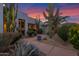 Lush landscaping featuring mature cacti, trees, and gravel pathways surround the property at sunset at 5914 E Dale Ln, Cave Creek, AZ 85331