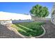 Expansive backyard with a lush lawn area, rock landscaping, and a privacy wall at 6014 W Bent Tree Dr, Phoenix, AZ 85083