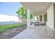 Covered patio with travertine tile, outdoor seating, and an open view of the landscaped backyard at 6014 W Bent Tree Dr, Phoenix, AZ 85083