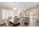 Bright dining area adjacent to kitchen features hardwood floors, modern lighting, and backyard views at 635 W Douglas Ave, Gilbert, AZ 85233