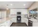 Modern kitchen featuring stainless steel appliances, white cabinets, granite countertops, and hardwood floors at 635 W Douglas Ave, Gilbert, AZ 85233