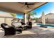 View of the covered patio and a pool, includes an umbrella for shade and seating at 635 W Douglas Ave, Gilbert, AZ 85233