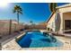 Sparkling pool with stone edging, desert landscaping, palm trees, and backyard privacy at 635 W Douglas Ave, Gilbert, AZ 85233