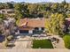 Stunning aerial view of a home with a terracotta tile roof, lush trees, and vibrant landscaping at 7607 E Charter Oak Rd, Scottsdale, AZ 85260