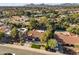 Aerial view of a home with a tile roof in a neighborhood setting near mountains and lush trees at 7607 E Charter Oak Rd, Scottsdale, AZ 85260