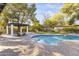 Landscaped backyard showcasing a swimming pool, an entertainment area, and mature trees at 7607 E Charter Oak Rd, Scottsdale, AZ 85260