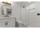 Modern bathroom featuring vertical tiled shower, a vanity with a sink and an arched mirror at 7607 E Charter Oak Rd, Scottsdale, AZ 85260