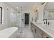 Modern bathroom featuring a soaking tub, a glass-enclosed shower, and double sink vanity with black hardware at 7607 E Charter Oak Rd, Scottsdale, AZ 85260