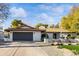 Charming home features a red tile roof, white brick, dark garage, and meticulously xeriscaped front yard at 7607 E Charter Oak Rd, Scottsdale, AZ 85260