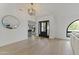 Bright foyer with light wood floors, modern lighting, and a front door with glass panels at 7607 E Charter Oak Rd, Scottsdale, AZ 85260