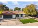 Charming home with a unique circular window, well-manicured lawn, and lush desert landscaping at 7607 E Charter Oak Rd, Scottsdale, AZ 85260