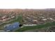 Overhead scenery of a golf course community with stunning water feature, lush green fairways, and surrounding desert homes at 9221 E Whitethorn Cir, Scottsdale, AZ 85266