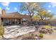 Backyard patio with a built-in grill, outdoor seating, and beautiful desert landscaping at 9221 E Whitethorn Cir, Scottsdale, AZ 85266