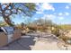 Desert backyard with a built-in grill, a stone patio, and mature landscaping at 9221 E Whitethorn Cir, Scottsdale, AZ 85266