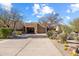 Desert landscaping enhances the front of this single-story home with neutral exterior and a large driveway at 9221 E Whitethorn Cir, Scottsdale, AZ 85266