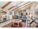 Spacious living room with beamed ceiling, wood flooring, fireplace, and comfortable seating at 9221 E Whitethorn Cir, Scottsdale, AZ 85266