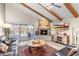 Bright living room with fireplace, beamed ceiling, wood flooring and access to the patio at 9221 E Whitethorn Cir, Scottsdale, AZ 85266