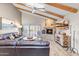 Living room with stone fireplace, wood floors, beamed ceiling and natural light at 9221 E Whitethorn Cir, Scottsdale, AZ 85266