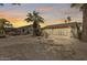 Backyard with desert landscaping, including palms and cacti, and a large sunroom addition on the home at 9513 E Hercules Dr, Sun Lakes, AZ 85248