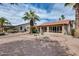 Wide shot of the backyard with desert landscaping, palm trees, and an enclosed patio at 9513 E Hercules Dr, Sun Lakes, AZ 85248