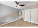 This bedroom features wood-look floors, a ceiling fan, a closet and white doors at 9513 E Hercules Dr, Sun Lakes, AZ 85248