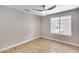 This bedroom features wood-look floors, a ceiling fan, and a large window at 9513 E Hercules Dr, Sun Lakes, AZ 85248