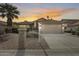 Inviting home featuring a tile roof, desert landscaping, and a two car garage under a colorful sunset at 9513 E Hercules Dr, Sun Lakes, AZ 85248