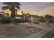 Charming home featuring desert landscaping with a palm tree and a tranquil rock feature enhancing the curb appeal at 9513 E Hercules Dr, Sun Lakes, AZ 85248