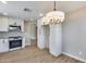 Spacious kitchen with stainless steel oven, white cabinets, light hardwood floors, and a modern chandelier at 9513 E Hercules Dr, Sun Lakes, AZ 85248