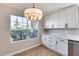 Kitchen dining area with a large window, white cabinets and counters, with pendant lighting to add ambiance at 9513 E Hercules Dr, Sun Lakes, AZ 85248