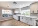 Open kitchen featuring bright windows, stainless steel appliances, white cabinets, and durable countertops for the home chef at 9513 E Hercules Dr, Sun Lakes, AZ 85248