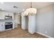 Kitchen with white cabinets and a stainless steel stove and microwave, with an adjacent dining area with a pendant light at 9513 E Hercules Dr, Sun Lakes, AZ 85248