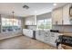 Bright kitchen with white cabinets, wood floor, stainless steel appliances, and view from dual windows at 9513 E Hercules Dr, Sun Lakes, AZ 85248