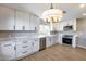 Bright modern kitchen with stainless steel appliances, white cabinetry, gorgeous counters and a pendant light at 9513 E Hercules Dr, Sun Lakes, AZ 85248