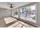 Bright sun room with wood floors, ceiling fan, and view of backyard landscaping through dual windows at 9513 E Hercules Dr, Sun Lakes, AZ 85248