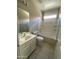 Bathroom with a tub, a window, neutral tile, and a single sink at 10030 W Illini St, Tolleson, AZ 85353