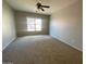 Bedroom with a ceiling fan, carpet flooring, and a bright window at 10030 W Illini St, Tolleson, AZ 85353