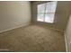 Neutral carpeted bedroom with a bright window, offering a calm and inviting space at 10030 W Illini St, Tolleson, AZ 85353