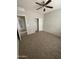 Clean bedroom with neutral carpet, ceiling fan, and closet perfect for relaxation at 10030 W Illini St, Tolleson, AZ 85353