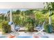 Overlooking backyard, serene back porch with white rocking chairs, lush greenery, and a tranquil view of nature's beauty at 1047 E 9Th St, Mesa, AZ 85203