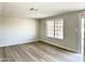 Empty living room featuring a window and updated floors at 1109 E Emerald Ave, Mesa, AZ 85204