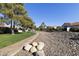 Scenic view of the neighborhood with lush landscaping, a paved walking path, and mature trees at 11115 E Bellflower Ct, Sun Lakes, AZ 85248