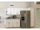 Spacious kitchen featuring white cabinetry, granite countertops, and stainless steel refrigerator at 11115 E Bellflower Ct, Sun Lakes, AZ 85248