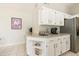 Bright kitchen featuring white cabinetry, granite countertops, and stainless steel refrigerator at 11115 E Bellflower Ct, Sun Lakes, AZ 85248