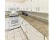 Well-lit kitchen featuring stainless steel appliances, granite counters and white cabinetry at 11115 E Bellflower Ct, Sun Lakes, AZ 85248